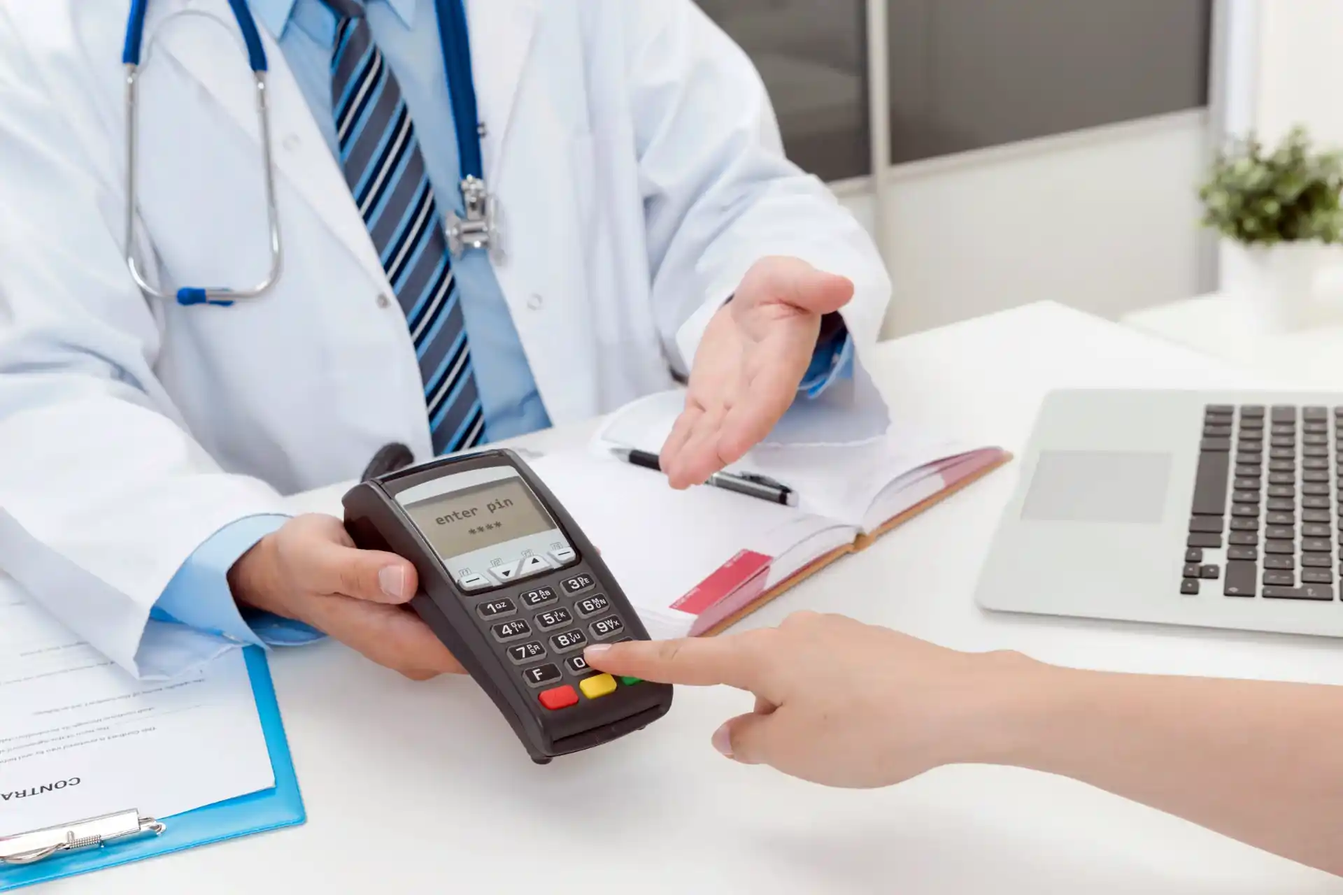 Hand of woman entering PIN in doctor's terminal