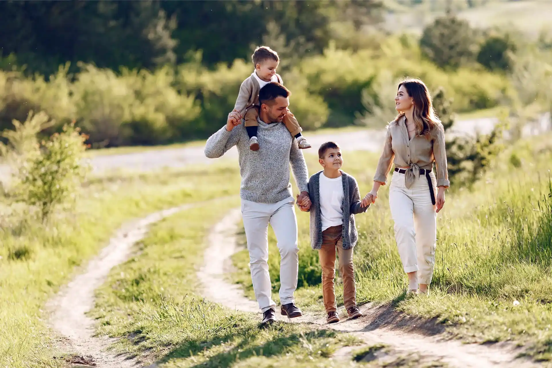 Happy family of four with good family insurance plan walking outdoors