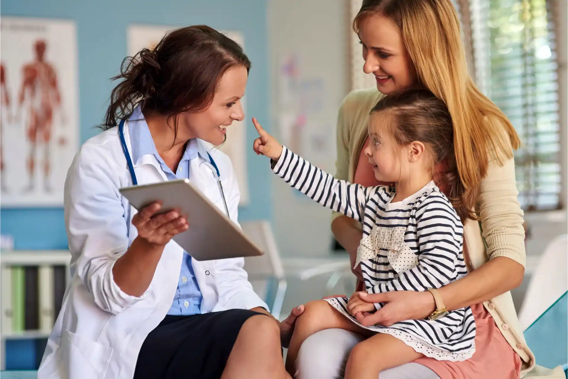 Little girl and mom with family insurance plan talking to smiling doctor