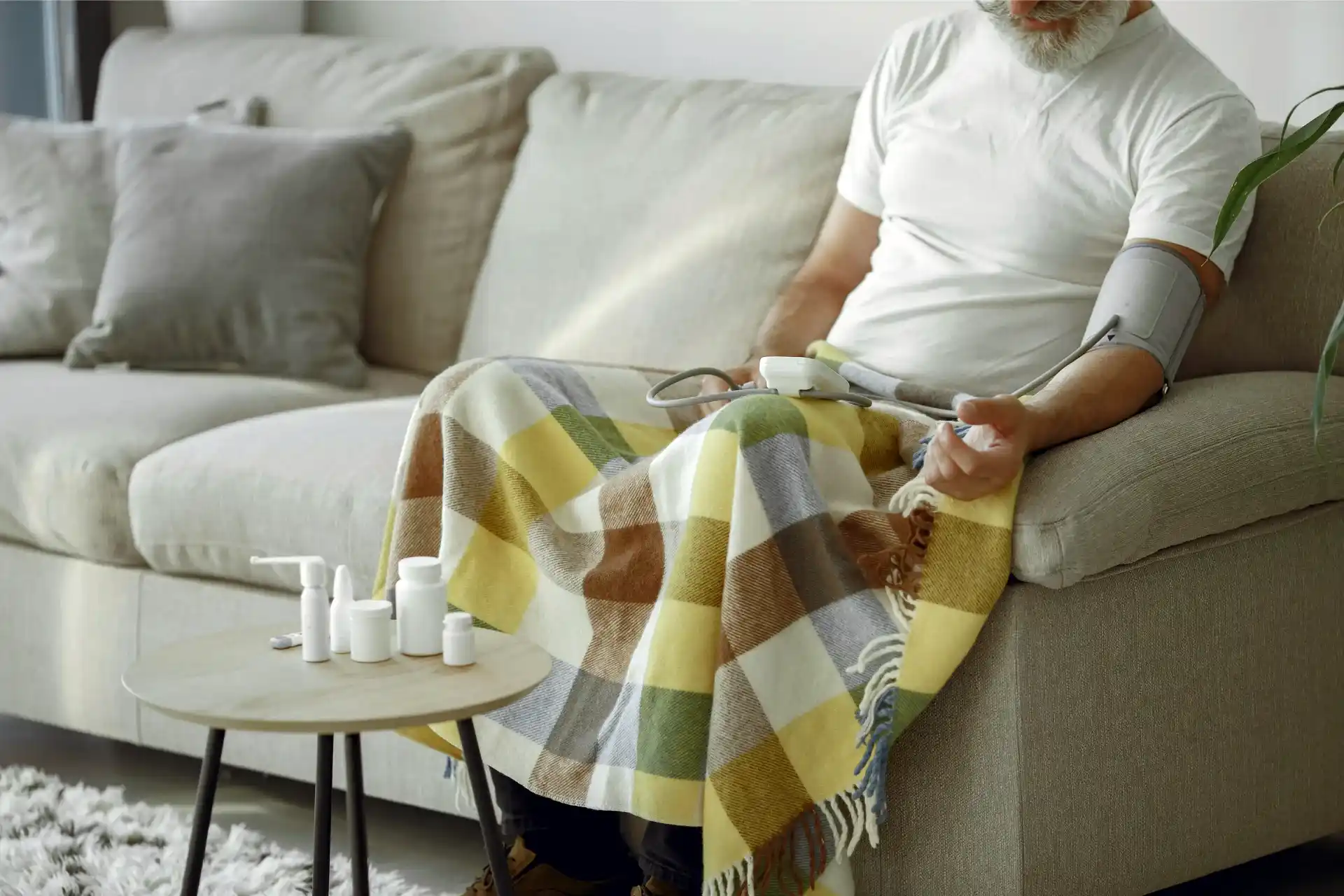 Senior man with long-term care insurance measuring own blood pressure