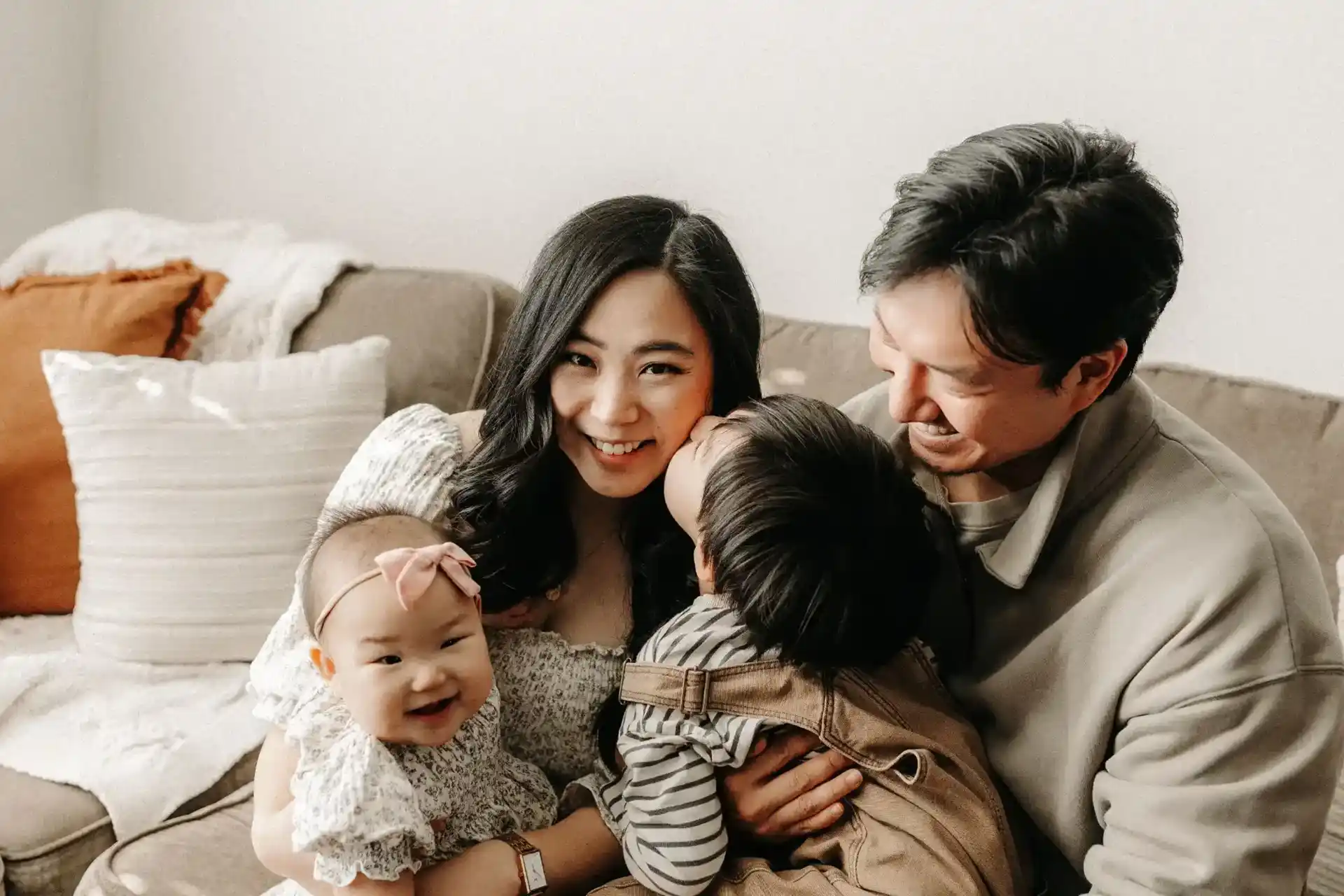 Happy family of four in a sofa