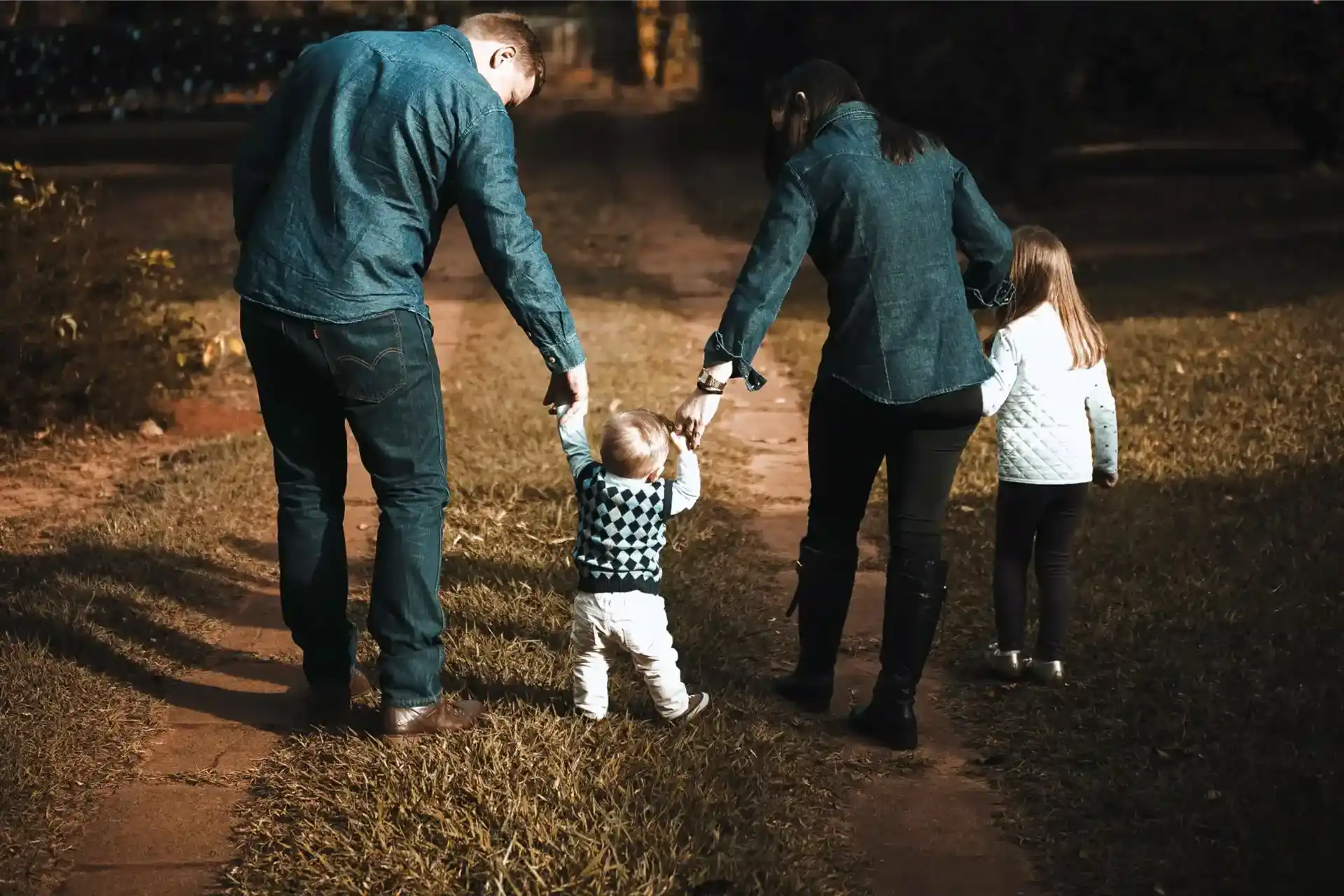 Parents with two kids walking a dirt road