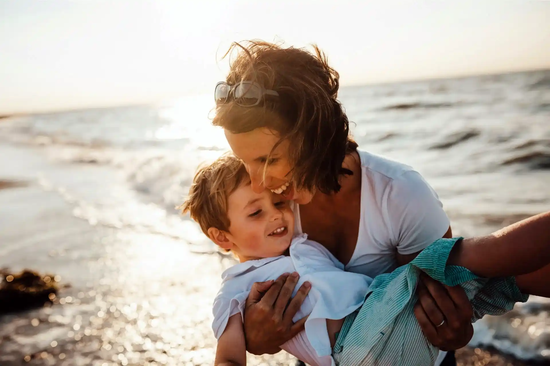 Mother with child in her hands by the beach